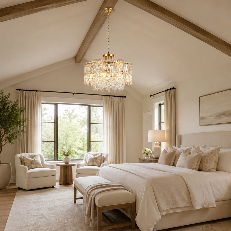 Gold-tone crystal chandelier shown in a bedroom with pitched ceiling