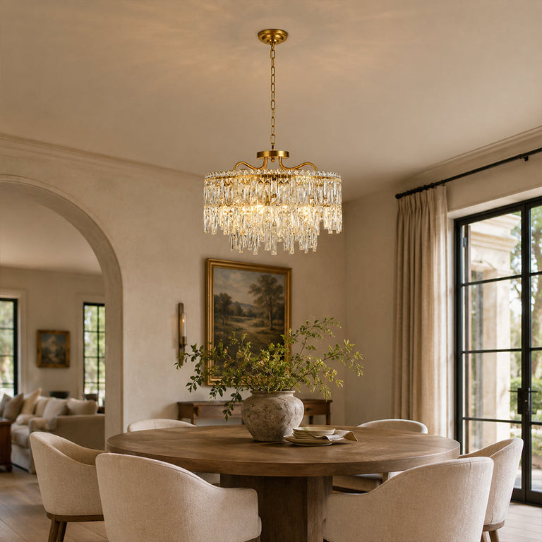 Gold-tone crystal chandelier shown in a dining room with rounded arch