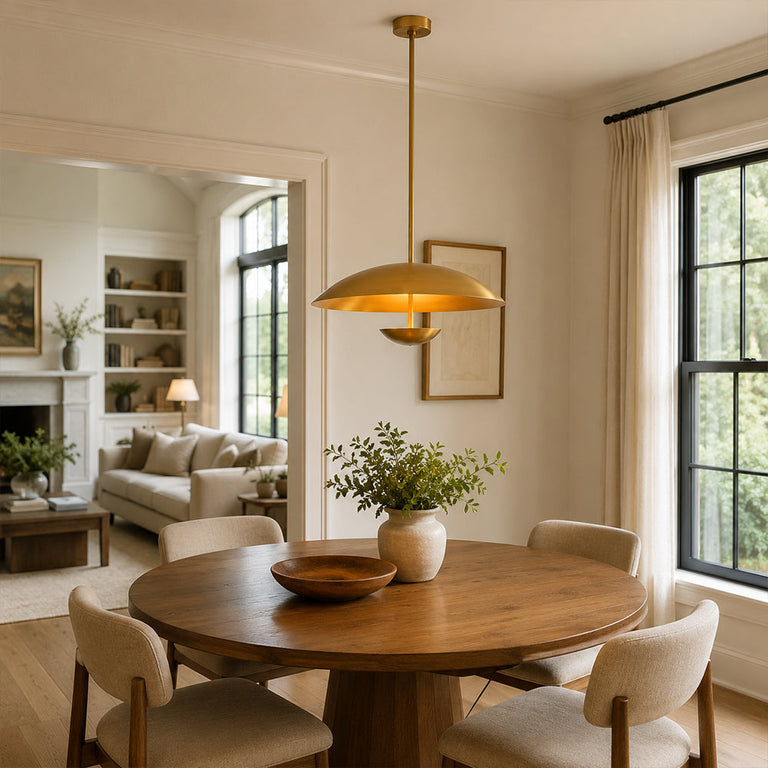 Gold-tone disc pendant above a round wooden dining table
