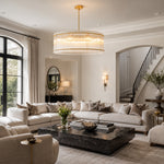 Gold-tone glass rod drum chandelier in a bright living room with a sectional sofa