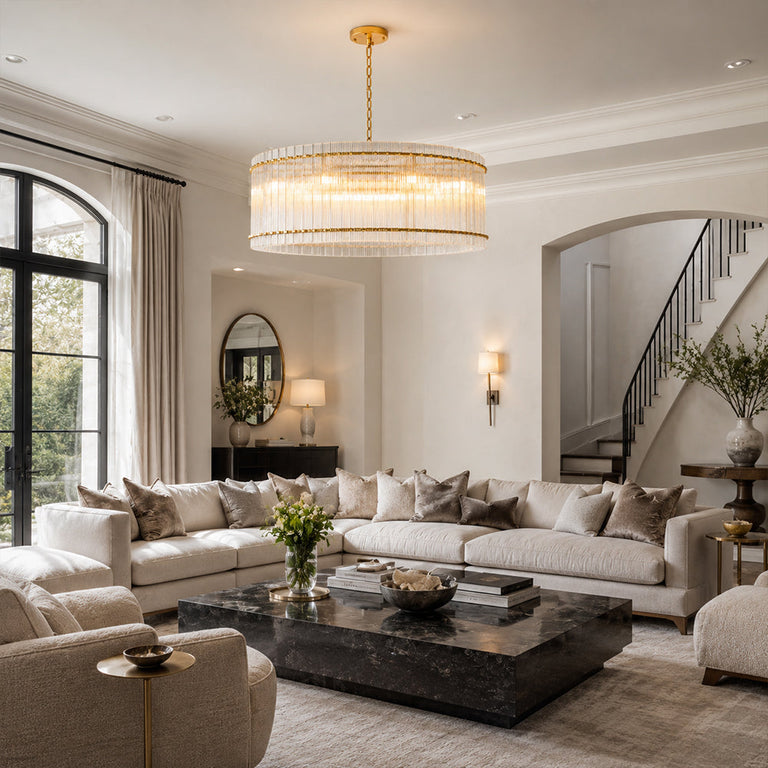Gold-tone glass rod drum chandelier in a bright living room with a sectional sofa