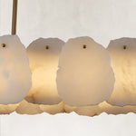 Gold-tone oval chandelier illuminated petal shade close view