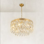 Gold-tone tiered crystal chandelier, complete fixture illuminated lower angle