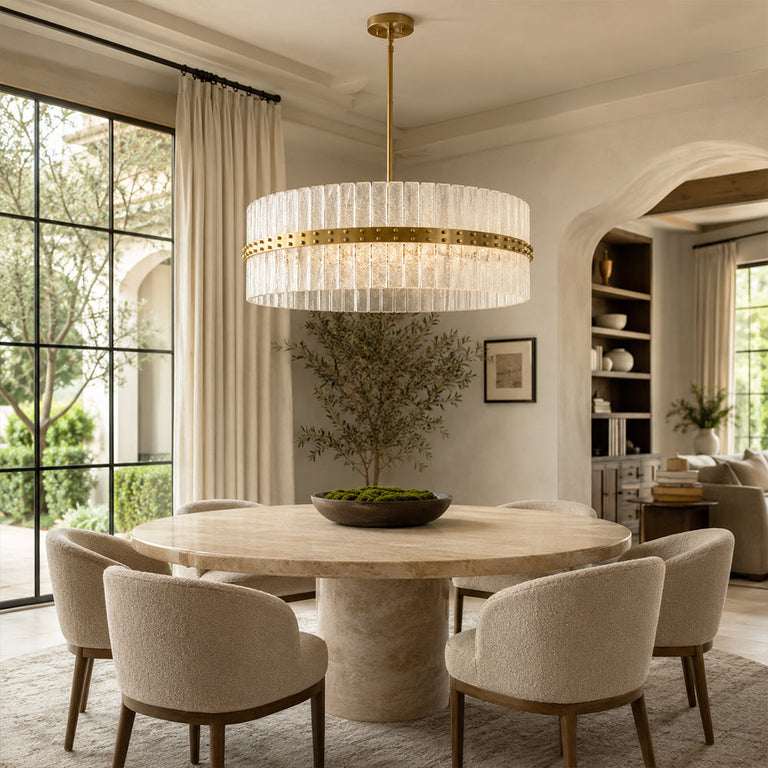 Glass drum chandelier above a round dining table beside an arched doorway.