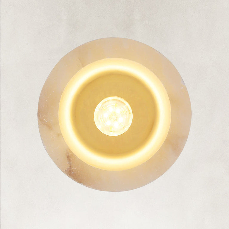 Illuminated underside of a cylindrical stone pendant.