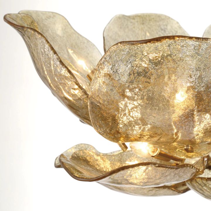 Close-up of overlapping gold glass petals and visible lights.
