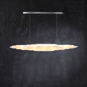 Front of an illuminated layered selenite pendant with a silver-tone canopy.