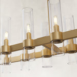 Linear glass-tube chandelier, brass-tone holders and staggered tubes.