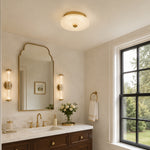 Low-profile textured glass flush mount above a vanity area