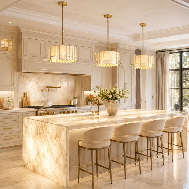 Scalloped single-tier drum pendants above pale stone kitchen island