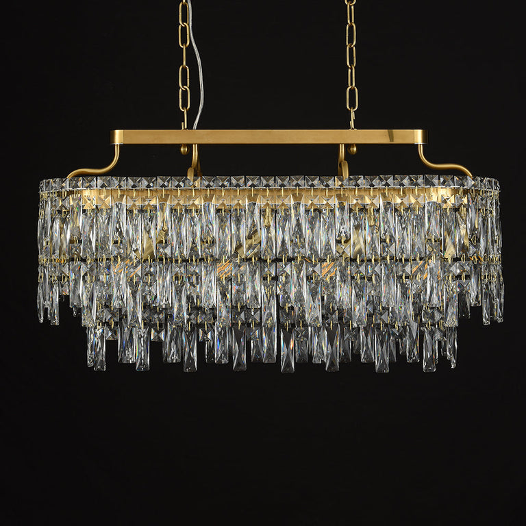 Gold-tone oval crystal chandelier, unlit fixture against dark background.