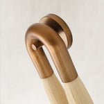 Bronze-tone U-shaped wall-sconce mount and off-white fiber detail.