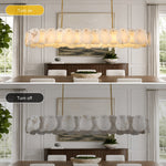 Brass-tone oval petal chandelier illuminated and unlit in a dining room.