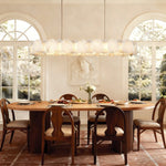 Petal Oval LED Chandelier in brass finish, shown above a dining table
