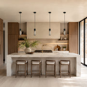 Matte-black ringed ribbed glass mini pendants over a kitchen island