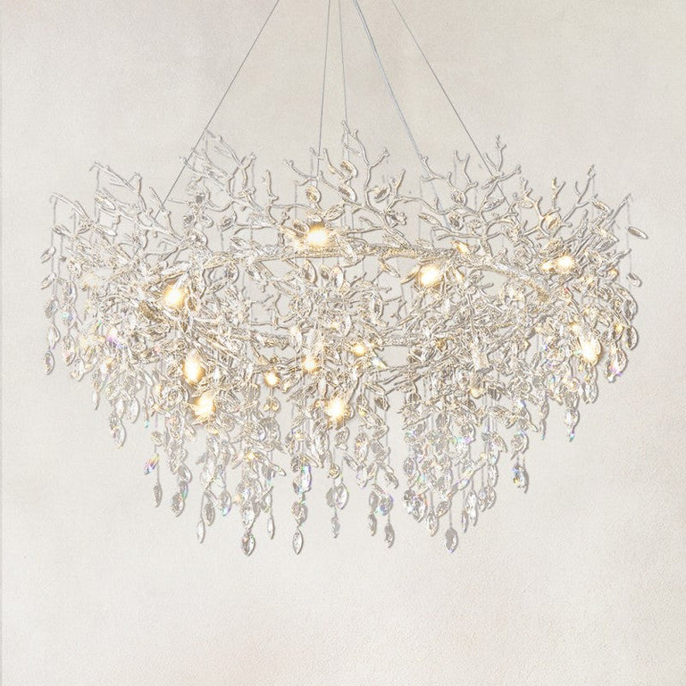 Silver branch ring chandelier with hanging clear crystal pendants against a warm textured background