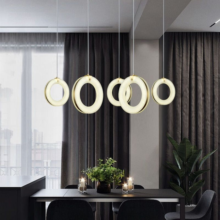 Alabaster ring lights arranged above a dining table.