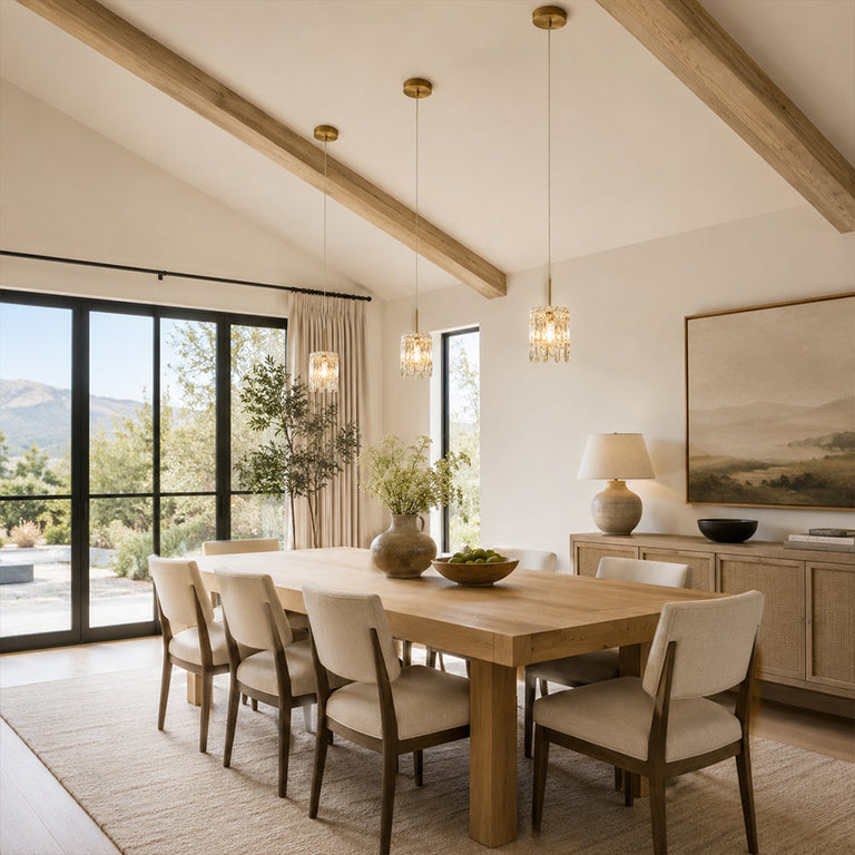 Three gold-tone crystal pendant lights shown over a dining table