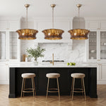 Three smoke ribbed-glass drum chandeliers above a kitchen island with white cabinetry