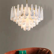 Alabaster panel chandelier hanging above a rust-colored sofa.