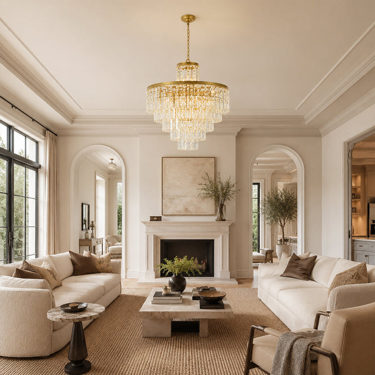 Tiered crystal drum chandelier over a round coffee table facing a plaster fireplace.