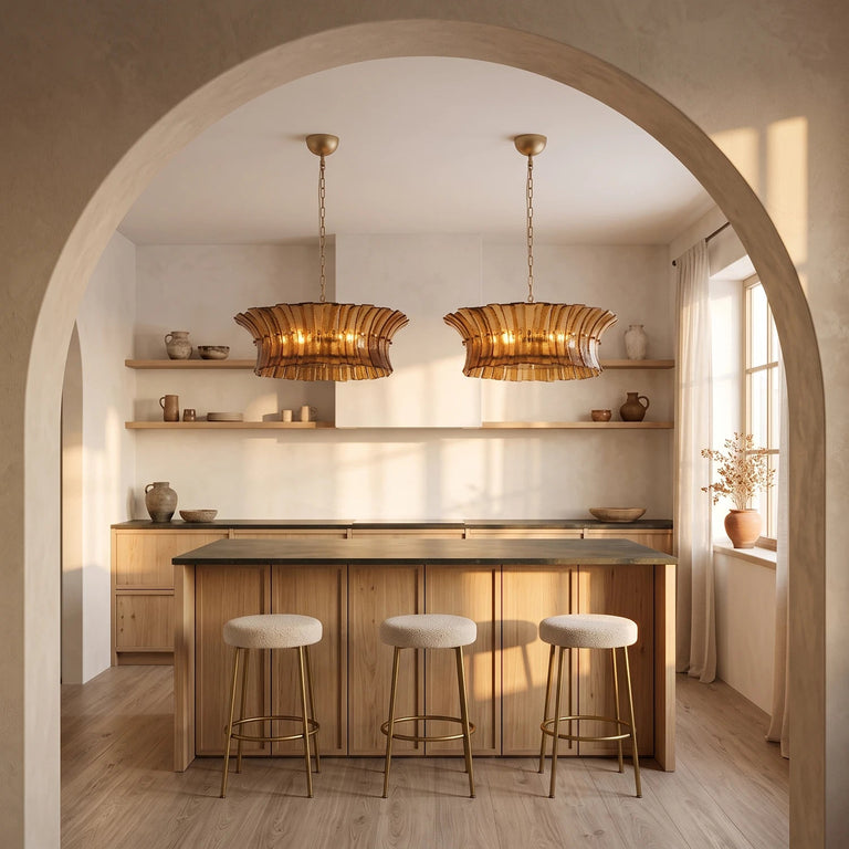 Two smoke ribbed-glass drum chandeliers above a wood kitchen island beneath an arch