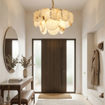 Two-tier alabaster disc chandelier illuminated above a furnished entryway