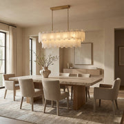 Brass-finish two-tier alabaster panel chandelier above a dining table
