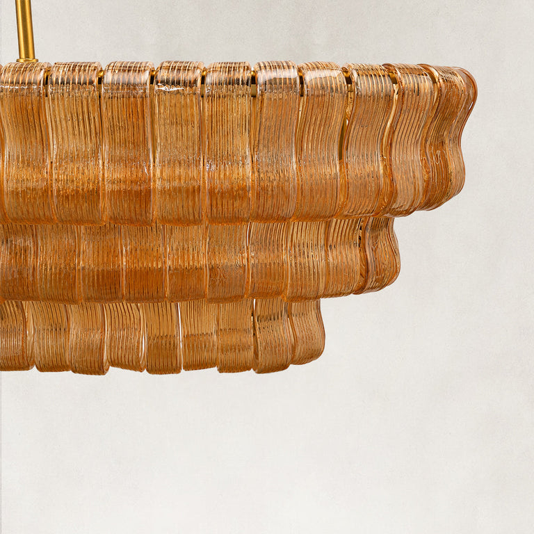 Unlit amber glass panels on the linear chandelier tiers.