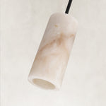 Unlit cylindrical stone pendant with a black rod.
