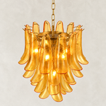 Close view of curved amber panels and the chandelier's upper support ring.