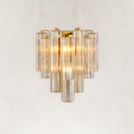 Illuminated wall sconce with tiered clear glass tubes and gold-tone hardware.